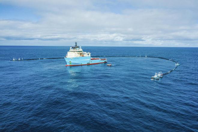 Ship of The Ocean Cleanup in the ocean with the first version of the cleanup system.